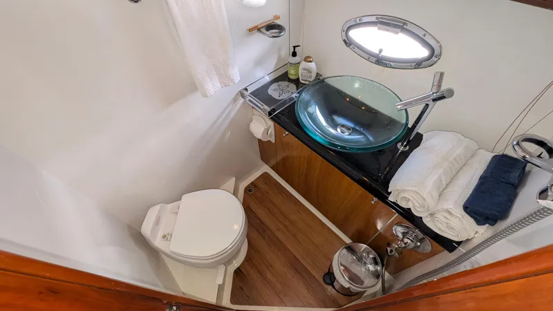 Cavallo Yacht Photos Pics Luxurious 2004 Sunseeker Portofino yacht bathroom with modern glass sink and wooden accents.