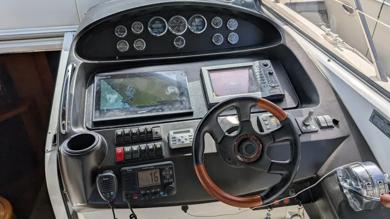 Cavallo Yacht Photos Pics Control panel of a 2004 Sunseeker Portofino yacht with steering wheel and navigation instruments.