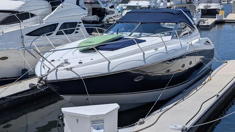 Cavallo Yacht Photos Pics 2004 Sunseeker Portofino yacht docked at marina, featuring sleek design and blue canopy.