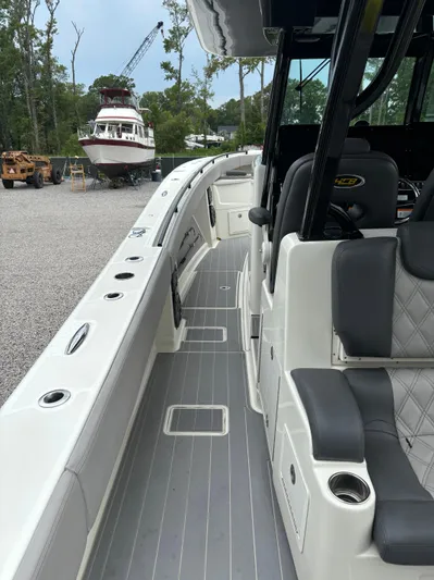  Yacht Photos Pics 2017 HCB Speciale boat interior with gray seating and deck, docked near other boats.