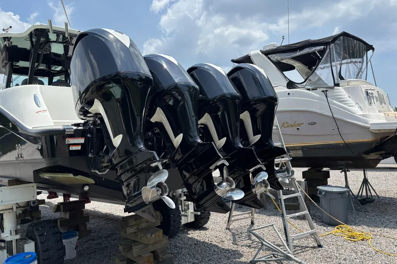  Yacht Photos Pics Four powerful outboard motors on a 2017 HCB Speciale boat, parked beside another vessel.