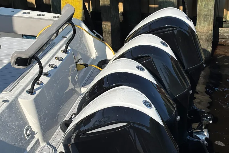  Yacht Photos Pics Four powerful outboard motors on a 2017 HCB Speciale boat docked by wooden piers.