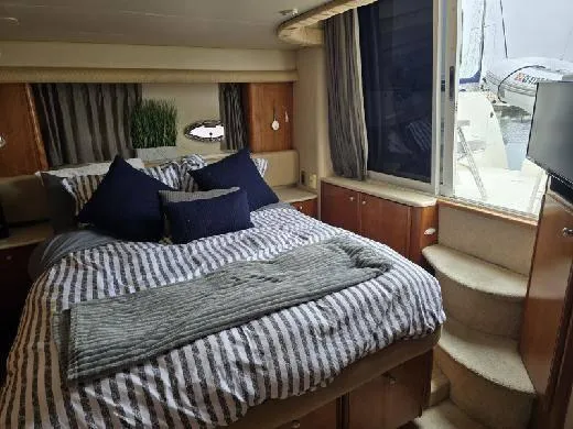 Embracing Life Yacht Photos Pics Luxurious bedroom in 2004 Meridian 459 Motoryacht with striped bedding and elegant decor.
