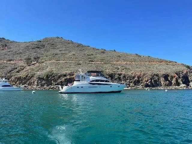 Embracing Life Yacht Photos Pics 2004 Meridian 459 Motoryacht on clear blue water near rocky coastline.