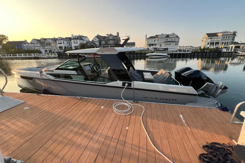  Yacht Photos Pics 2023 Saxdor 320 GTO docked at a marina, surrounded by waterfront homes.