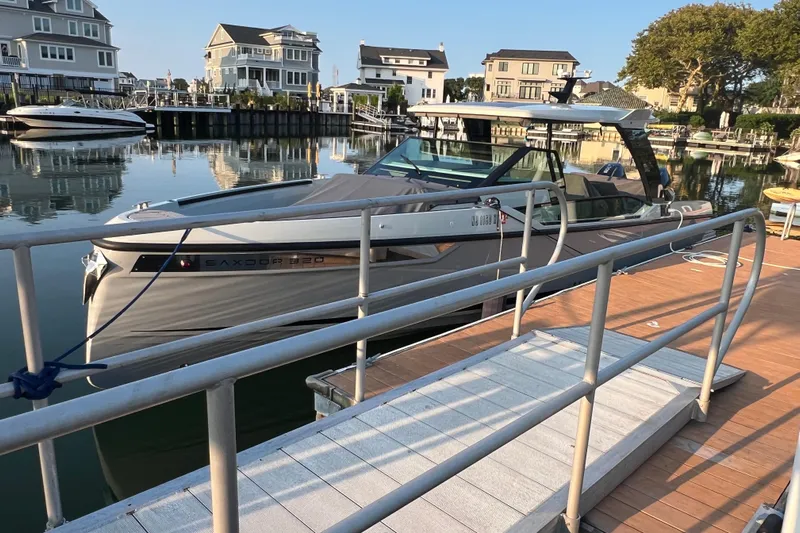  Yacht Photos Pics 2023 Saxdor 320 GTO docked in a serene residential marina setting.