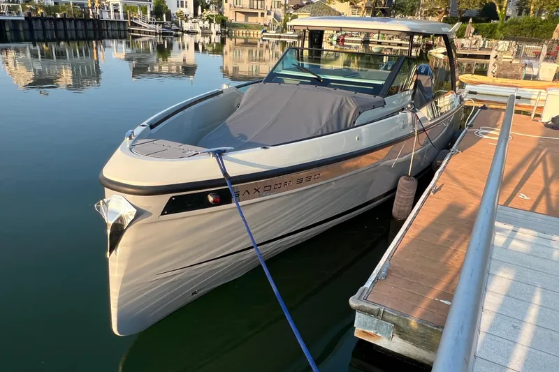  Yacht Photos Pics 2023 Saxdor 320 GTO boat docked at a marina, reflecting on calm water.