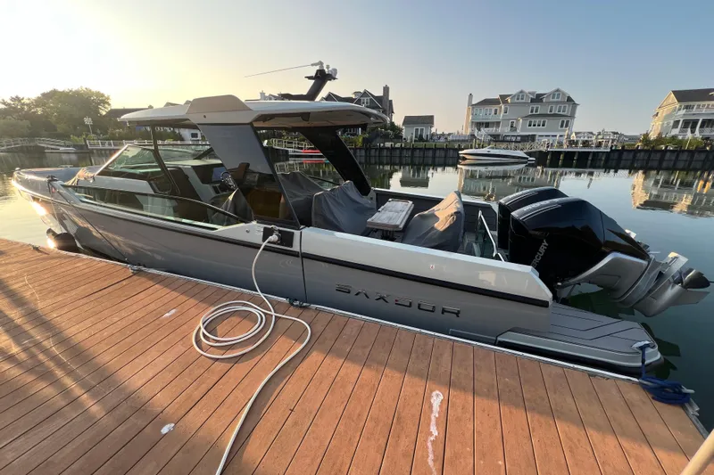  Yacht Photos Pics 2023 Saxdor 320 GTO boat docked at a serene waterfront with modern homes.