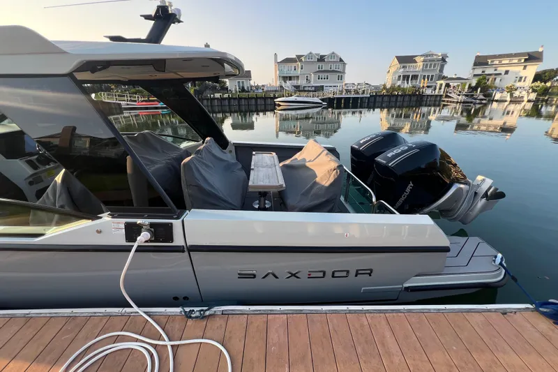  Yacht Photos Pics 2023 Saxdor 320 GTO docked at a marina with modern waterfront homes.