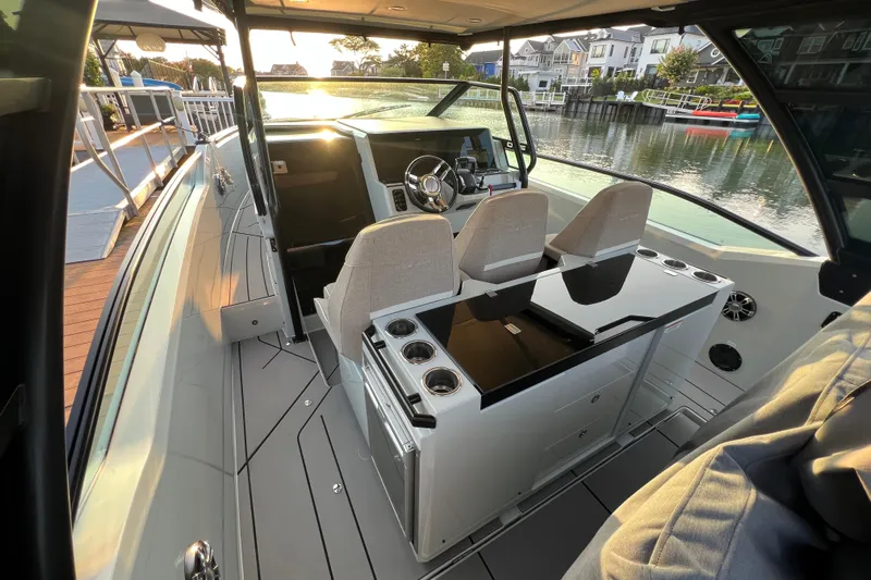  Yacht Photos Pics 2023 Saxdor 320 GTO boat interior with modern helm and seating, docked by waterfront homes.