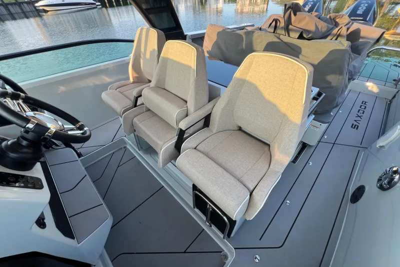  Yacht Photos Pics 2023 Saxdor 320 GTO interior with modern seating and steering wheel, docked by water.