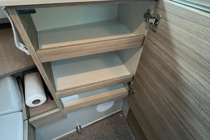  Yacht Photos Pics Interior storage shelves in 2023 Saxdor 320 GTO boat, featuring wood finish and open cabinet.