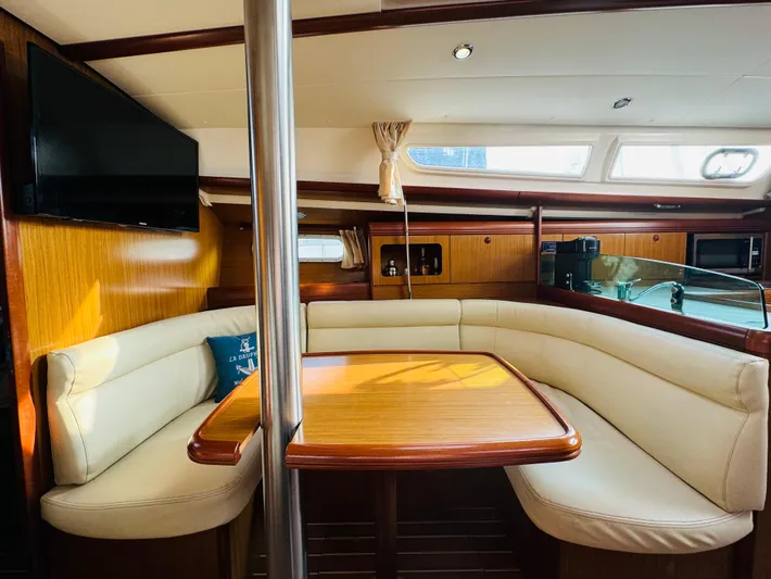 La Dauphine Yacht Photos Pics Interior of 2007 Jeanneau Sun Odyssey 36i yacht with cozy seating and wooden table.