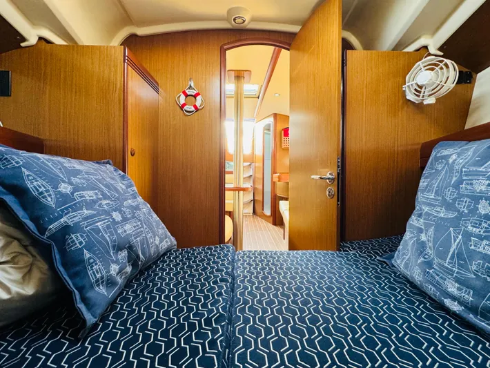 La Dauphine Yacht Photos Pics Interior cabin of 2007 Jeanneau Sun Odyssey 36i sailboat, featuring nautical-themed bedding.