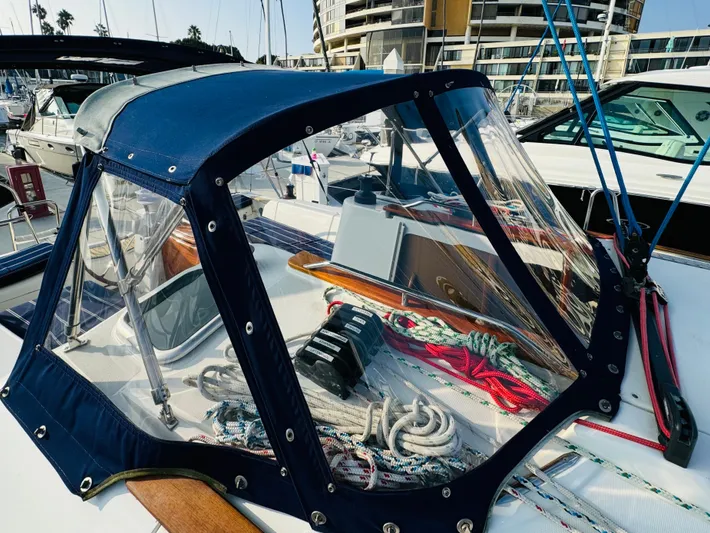 La Dauphine Yacht Photos Pics 2007 Jeanneau Sun Odyssey 36i sailboat cockpit with blue canopy and marina background.