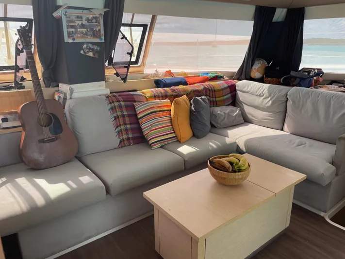 Anth'r'flo Yacht Photos Pics Cozy interior of 2017 Fountaine Pajot Helia catamaran with colorful cushions and guitar.