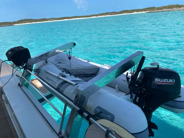 Anth'r'flo Yacht Photos Pics 2017 Fountaine Pajot Helia with dinghy on turquoise water, clear sky, and distant shoreline.