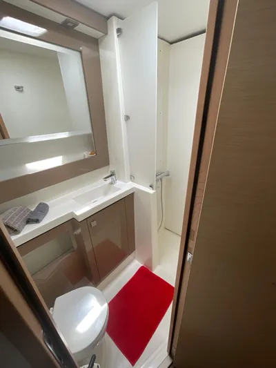 Anth'r'flo Yacht Photos Pics 2017 Fountaine Pajot Helia bathroom with modern fixtures, red mat, and sleek cabinetry.