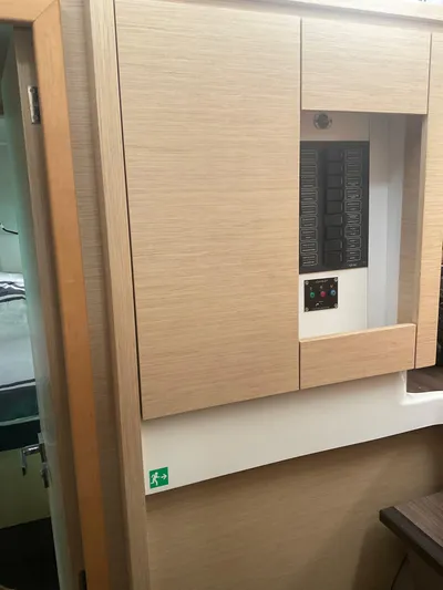 Anth'r'flo Yacht Photos Pics Electrical panel inside 2017 Fountaine Pajot Helia catamaran, featuring wooden cabinetry.