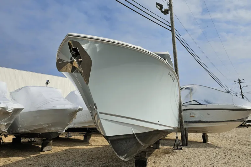  Yacht Photos Pics 2023 Sailfish 316 DC boat on display, wrapped and elevated outdoors.