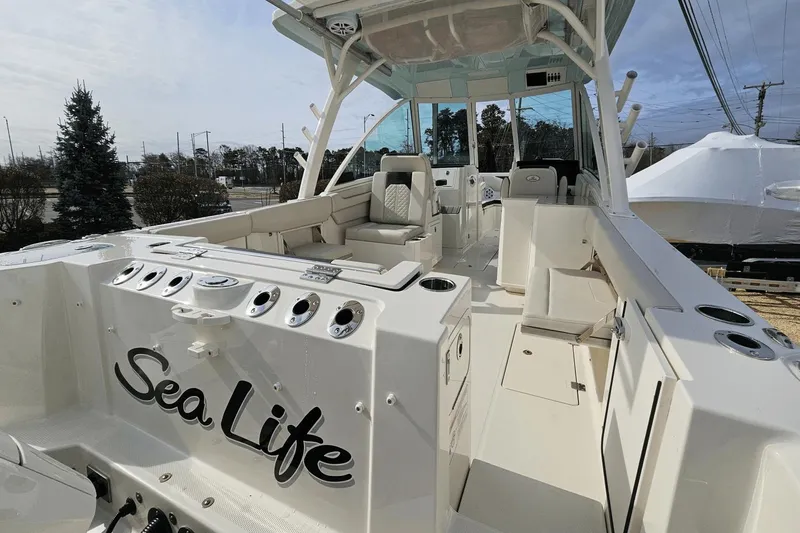  Yacht Photos Pics 2023 Sailfish 316 DC boat interior with seating and "Sea Life" text on the side.