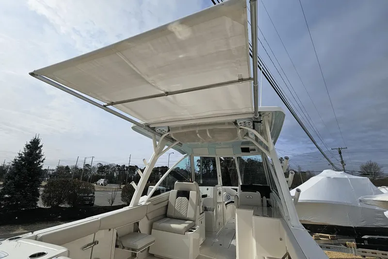 Yacht Photos Pics 2023 Sailfish 316 DC boat with spacious seating and canopy, docked outdoors.