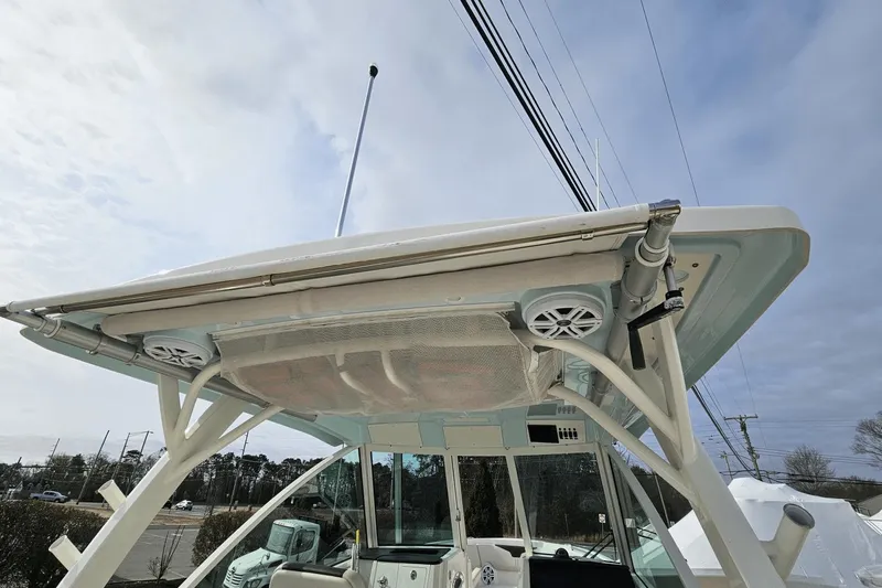  Yacht Photos Pics 2023 Sailfish 316 DC boat with speakers and canopy under a cloudy sky.
