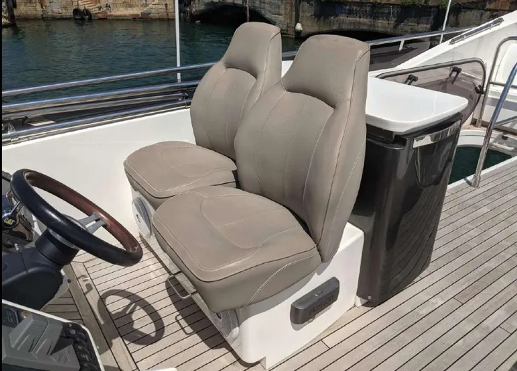  Yacht Photos Pics Flybridge seating on 2014 Princess 52 yacht with dual beige seats and wooden steering wheel.