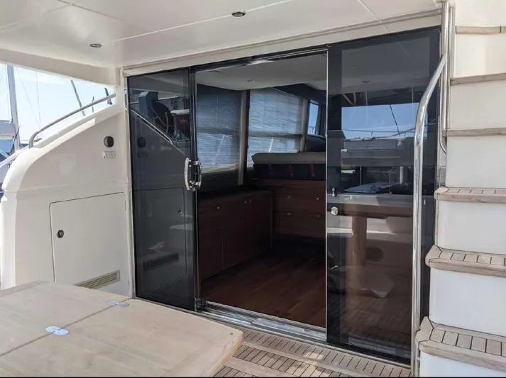  Yacht Photos Pics Luxurious 2014 Princess 52 Flybridge yacht interior with sliding glass doors and wooden flooring.