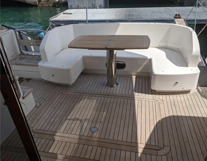  Yacht Photos Pics Flybridge seating area on 2014 Princess 52 yacht with wooden table and deck.