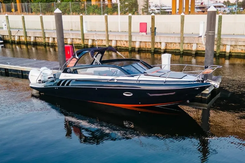 Yacht Photos Pics 2024 Hanover 305 Sport Edition boat docked at marina, sleek design, black and orange accents.