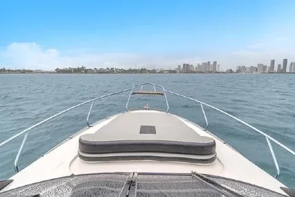  Yacht Photos Pics 2024 Hanover 305 Sport Edition boat cruising on open water with city skyline.