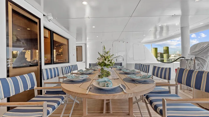 My Spirit Yacht Photos Pics Luxurious 2005 New Zealand Yachts Wave Piercer dining area with elegant table setting and striped chairs.