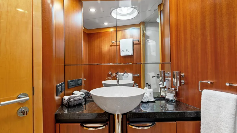My Spirit Yacht Photos Pics Luxurious yacht bathroom with modern sink, wooden cabinetry, and mirrored walls on 2005 New Zealand Yachts Wave Piercer.