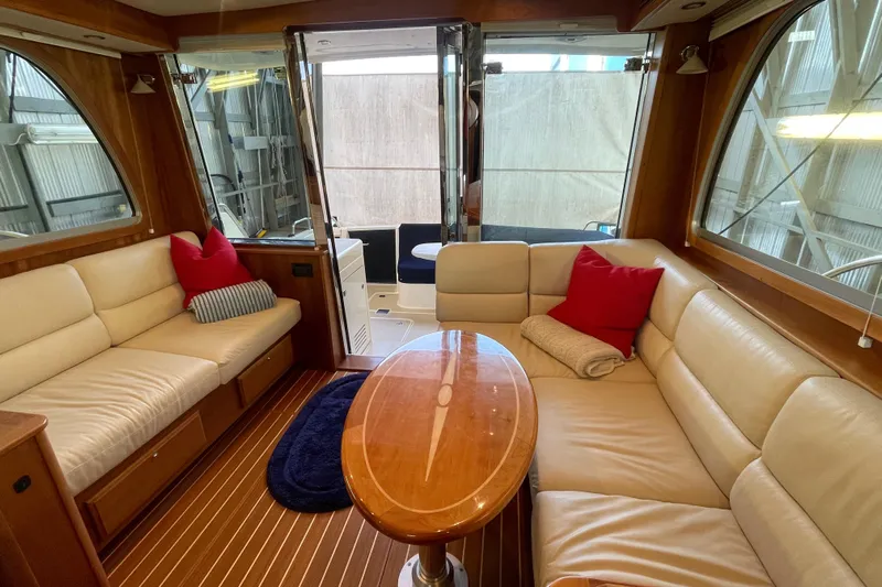  Yacht Photos Pics 2014 Sabre 42 Salon Express interior with beige leather seating and wooden table.