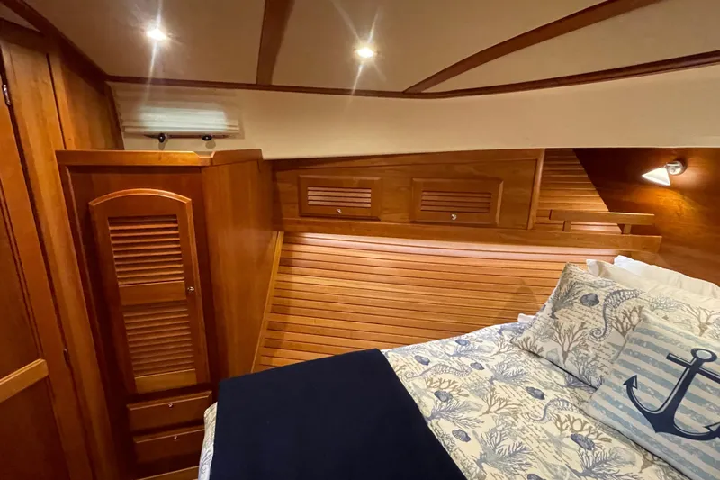  Yacht Photos Pics Luxurious 2014 Sabre 42 Salon Express cabin with wooden interior and nautical-themed bedding.