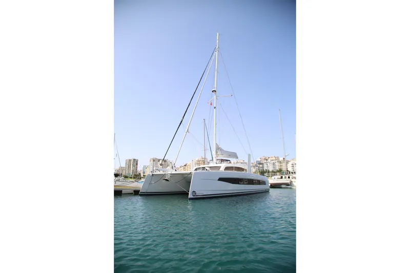 Heby Yacht Photos Pics 2023 Catana OC 50 catamaran docked in a marina, clear blue sky background.