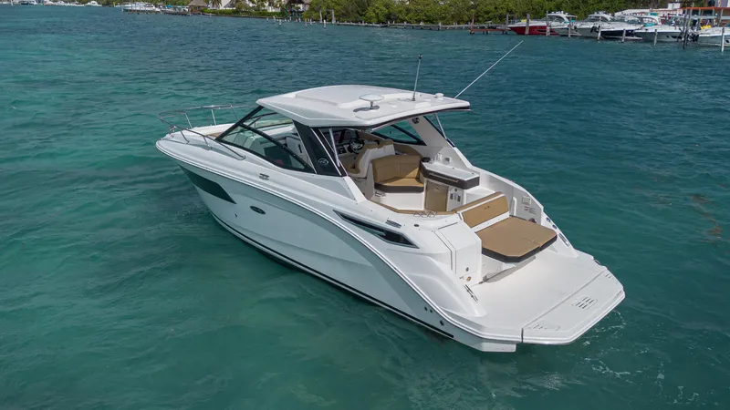 White Kraken Yacht Photos Pics 2023 Sea Ray Sundancer 320 yacht on clear blue water, showcasing sleek design and spacious deck.