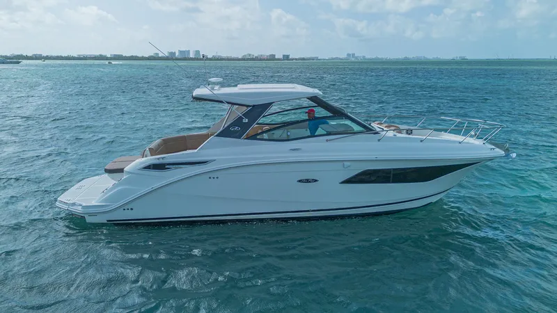 White Kraken Yacht Photos Pics 2023 Sea Ray Sundancer 320 cruising on open water under a clear sky.