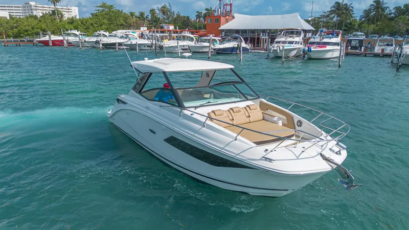 White Kraken Yacht Photos Pics 2023 Sea Ray Sundancer 320 cruising in a marina with clear blue water.