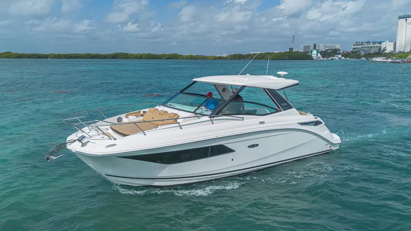 White Kraken Yacht Photos Pics 2023 Sea Ray Sundancer 320 cruising on clear blue water under a partly cloudy sky.