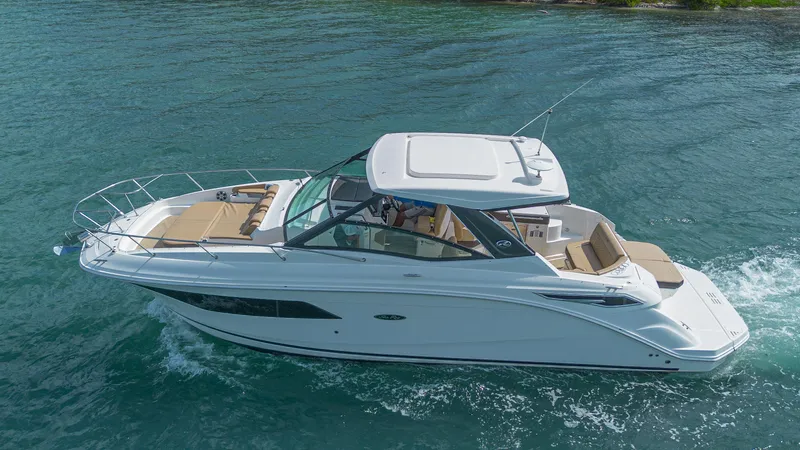White Kraken Yacht Photos Pics 2023 Sea Ray Sundancer 320 cruising on clear blue water.
