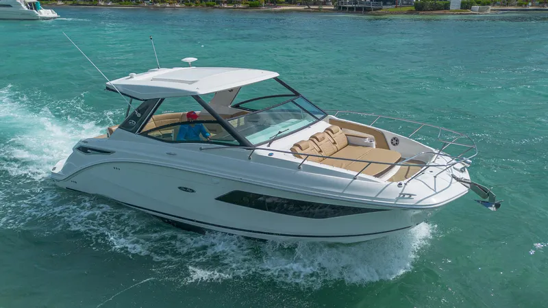 White Kraken Yacht Photos Pics 2023 Sea Ray Sundancer 320 cruising on clear turquoise waters.