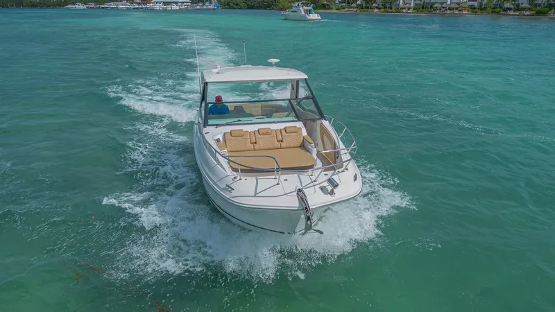 White Kraken Yacht Photos Pics 2023 Sea Ray Sundancer 320 cruising on turquoise waters, showcasing sleek design and luxury.