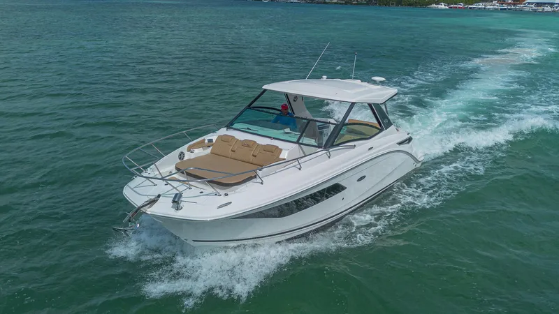 White Kraken Yacht Photos Pics 2023 Sea Ray Sundancer 320 cruising on clear blue water.