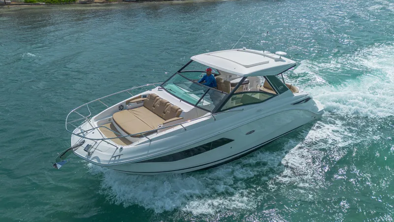 White Kraken Yacht Photos Pics 2023 Sea Ray Sundancer 320 cruising on clear blue water.