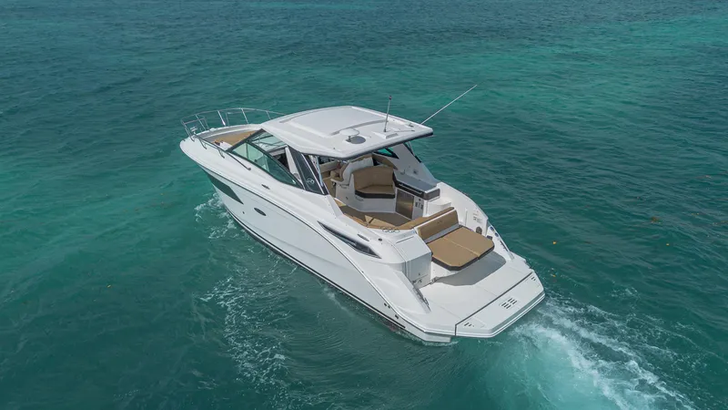 White Kraken Yacht Photos Pics 2023 Sea Ray Sundancer 320 cruising on clear turquoise waters.