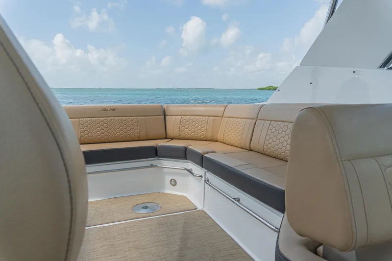 White Kraken Yacht Photos Pics 2023 Sea Ray Sundancer 320 interior with beige seating, ocean view, and clear sky.