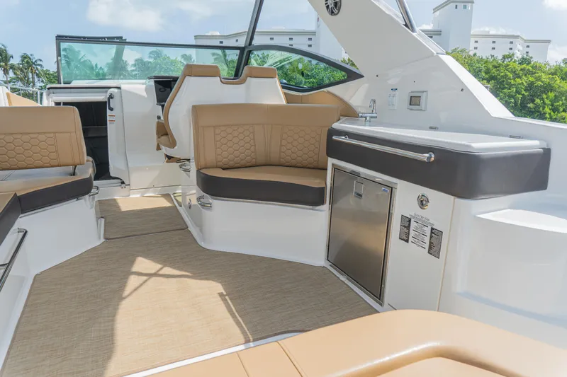 White Kraken Yacht Photos Pics 2023 Sea Ray Sundancer 320 interior with tan seating and modern amenities.