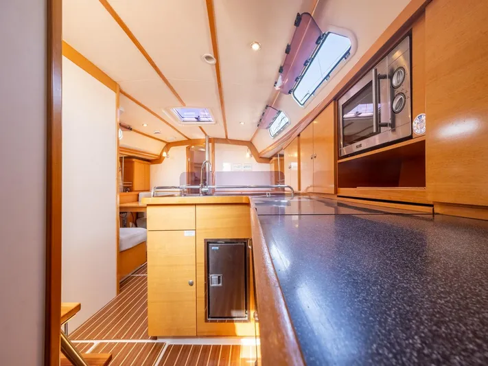  Yacht Photos Pics Interior of 2006 Hanse 370 yacht, featuring modern kitchen and wooden cabinetry.